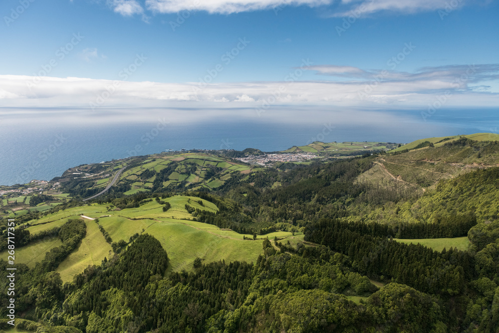 aerial landscape views on green hills, pastures and the ocean as seen from Lagoa do Fogo (Lake/ Lagoon of Fire) in direction to the south coast of Sao Miguel Island aerial landscape views on green hills, pastures and the ocean as seen from Lagoa do Fogo (Lake/ Lagoon of Fire) in direction to the south coast of Sao Miguel Island