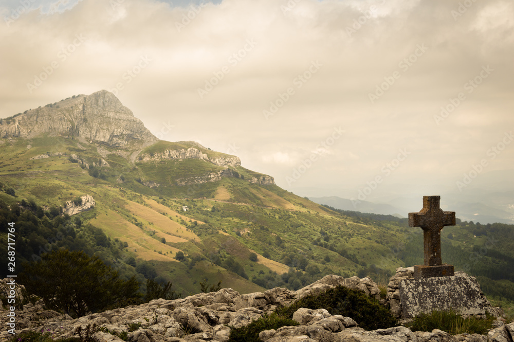 Fototapeta premium Standing empty on top of a mountain viewpoint with a cross in Gorbea park. Basque Country, Spain.