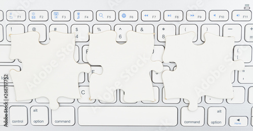 Three blank puzzle pieces on a keyboard