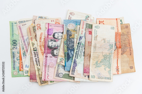 Different banknotes from all over the world spread on white background