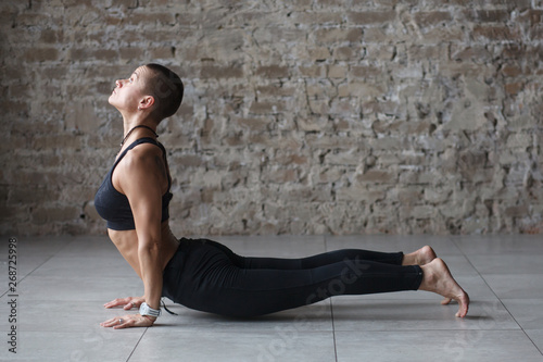 young skinhead woman doing yoga exercise - Upward-Facing Dog indoor