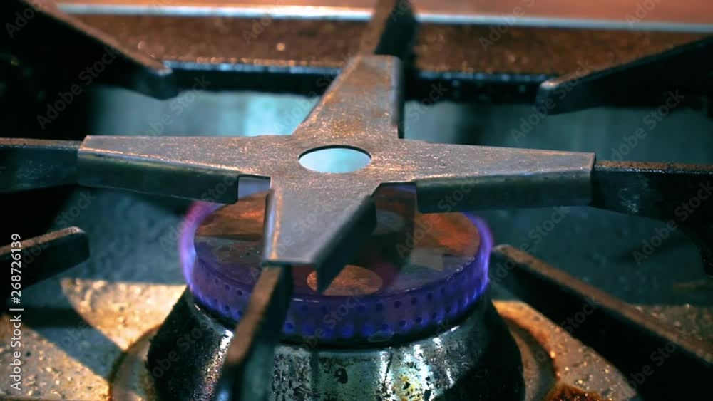 Close up blue cooking gas flame on gas stove burner in kitchen. Close up blue cooking gas flame on gas stove burner in kitchen.
