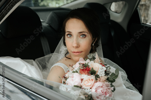 bride sits in the car on your wedding. bride in a car window