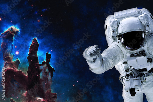Fototapeta Naklejka Na Ścianę i Meble -  Space astronaut near pillars of creation. Space adventure in outer space. Science fiction. Elements of this image were furnished by NASA 