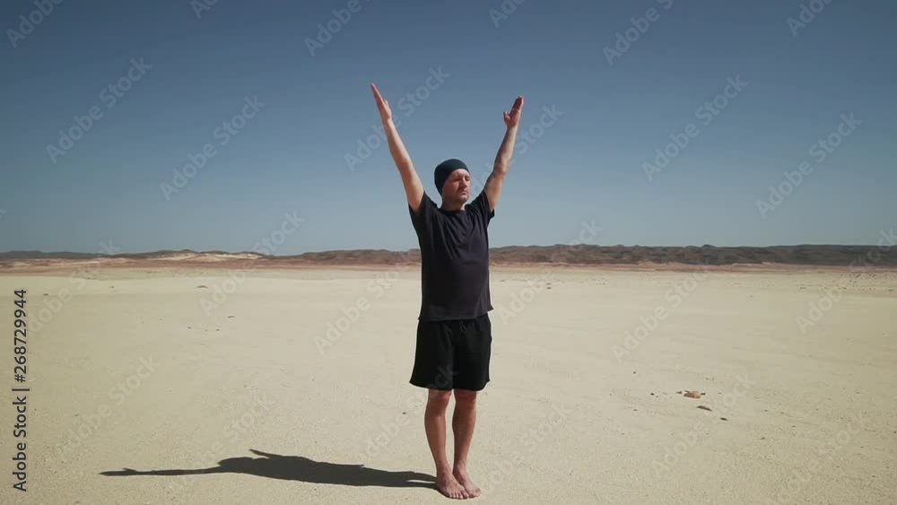 Handsome male doing yoga tadasana namaste at rock in desert 4k Handsome male doing yoga tadasana namaste at rock in desert 4k
