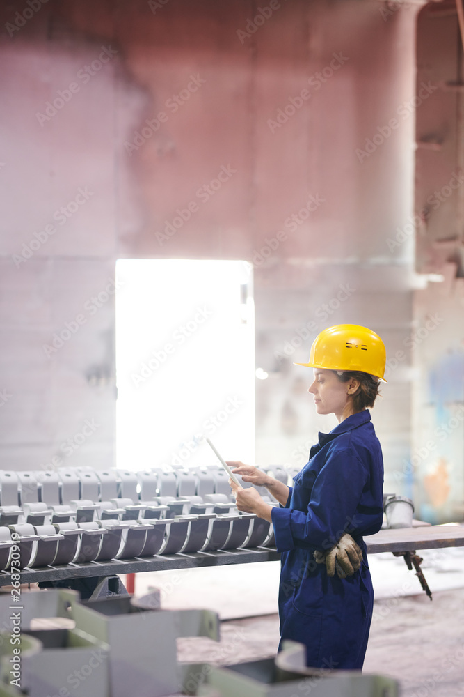 Side view portrait of female worker holding digital tablet while supervising production at plant, copy space