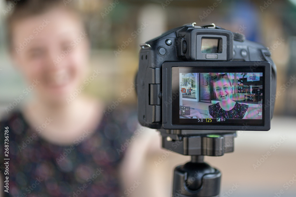 A caucasian young girl making a video blog (vlog) behind the camera A caucasian young girl making a video blog (vlog) behind the camera
