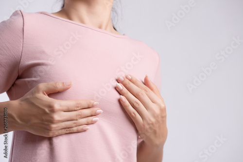 Wallpaper Mural Woman hand checking lumps on her breast for signs of breast cancer on gray background. Healthcare concept. Torontodigital.ca