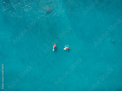 Aerial view of surfers in tropical ocean. Top view