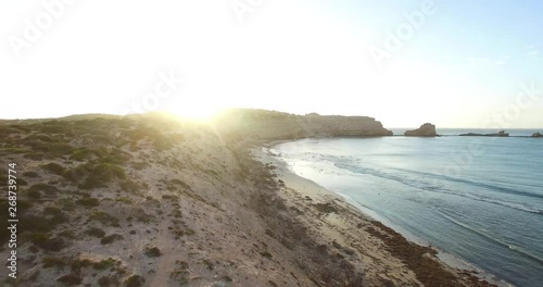 Rocky coastline at sunset in a slow descending aerial photo