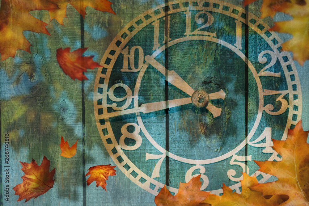 Clock and autumn leaves background - daylight saving time concept Clock and autumn leaves background - daylight saving time concept
