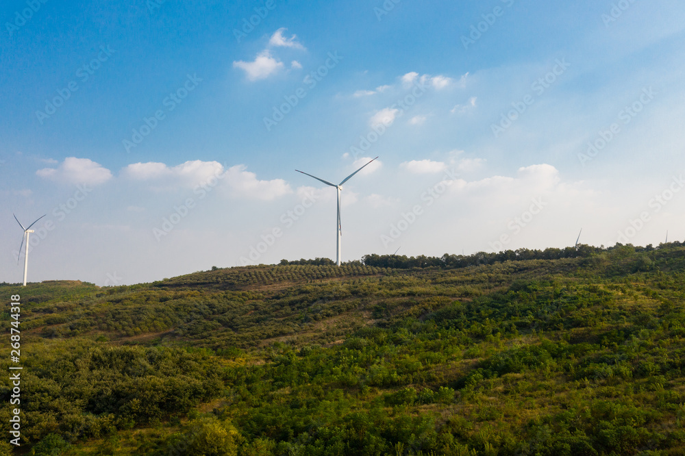 The windmills on the top of a mountain. They generate green energy from the nature. The windmills on the top of a mountain. They generate green energy from the nature.