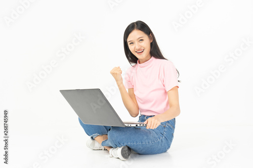 Happy asian teen passenger listening to the music with headphones while holding mobile phone.businesswoman listening to music with headphones while dancing isolated over white background