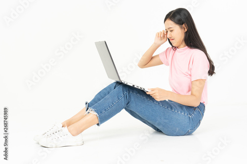 Happy asian teen passenger listening to the music with headphones while holding  mobile phone.businesswoman listening to music with headphones while dancing isolated over white background © anon