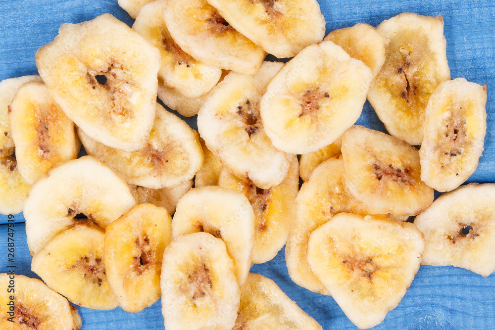 Dried banana chips for snack or dessert on blue boards Dried banana chips for snack or dessert on blue boards