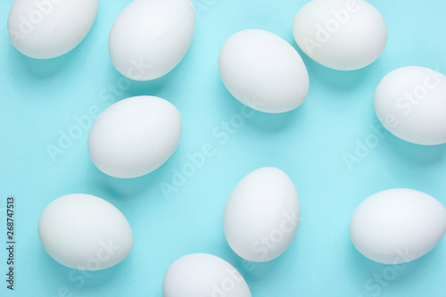 Minimalism food concept. A lot of eggs on a blue background. Top view