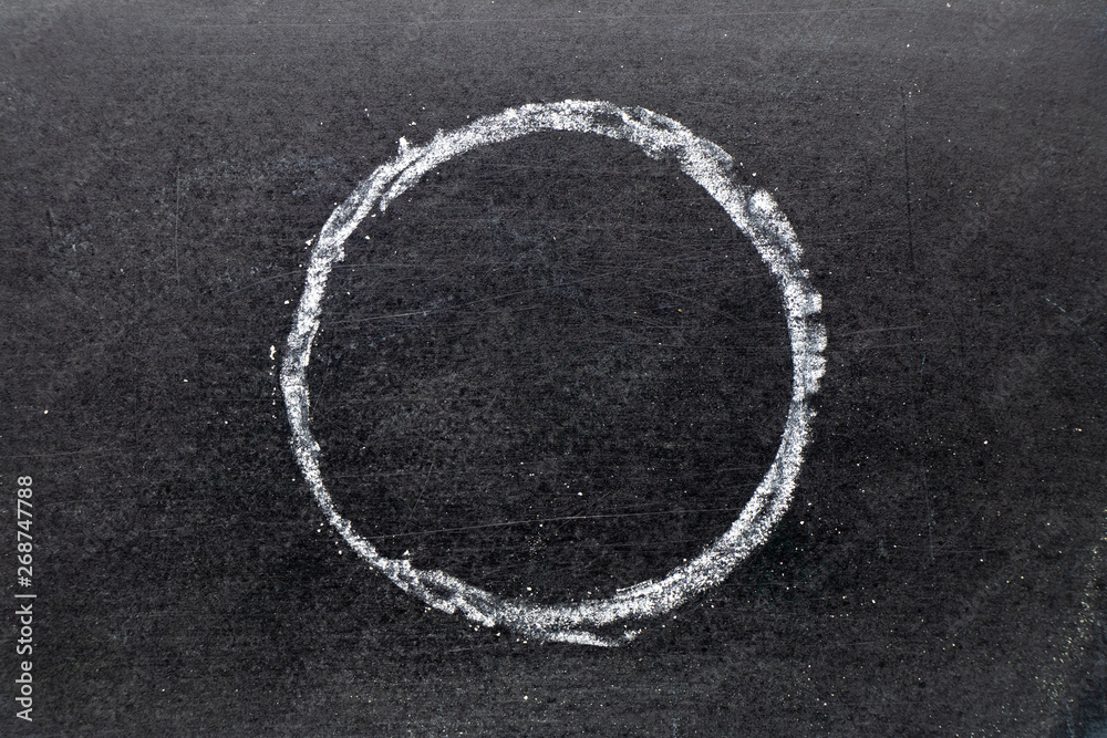 White chalk drawing as circle shape on black board background
