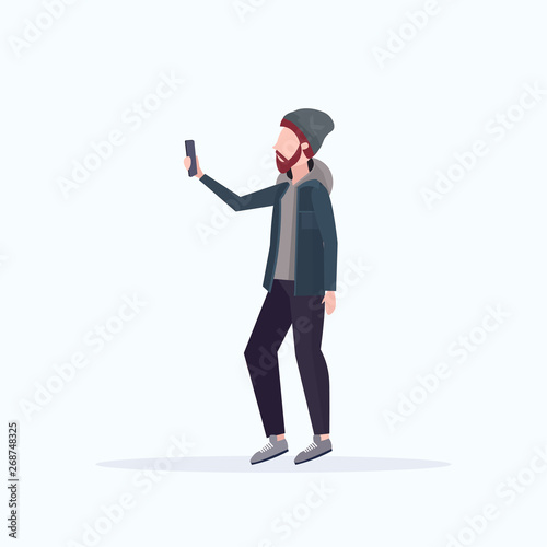 man taking selfie photo on smartphone camera casual male cartoon character in hat posing on white background flat full length