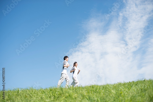 草原でジョギングをするカップル
