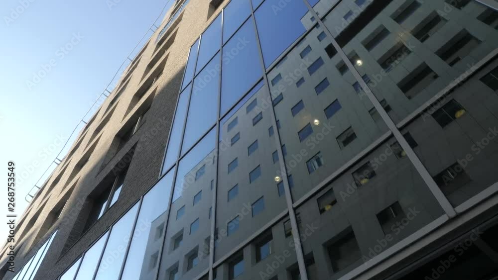 4K video with pan motion of the exterior facade of a financial office building in the Barcode quarter of Bjoervika in Oslo, with reflections of another building in the blue/dark windows. 4K video with pan motion of the exterior facade of a financial office building in the Barcode quarter of Bjoervika in Oslo, with reflections of another building in the blue/dark windows.