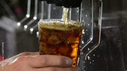 Filling a glass with cola on at a soda fountain