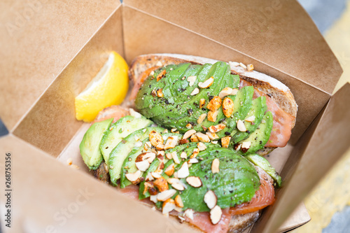 Healthy Food, Avocado Toasts with Sliced Salmon and Almond in the Take away lunch box.