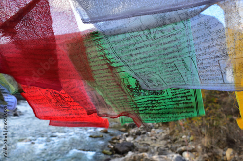 walking suspension bridge over the river with colorful prayer flags in Bhutan photo