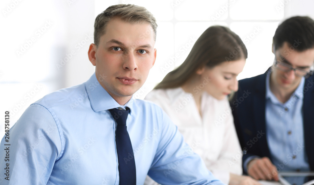 Group of business people discussing questions at meeting in modern office. Headshot of businessman at negotiation. Teamwork, partnership and business concept Group of business people discussing questions at meeting in modern office. Headshot of businessman at negotiation. Teamwork, partnership and business concept