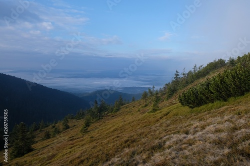 Babia Gora - mountain range in Beskid Zywiecki during spring with fog, clouds and sun