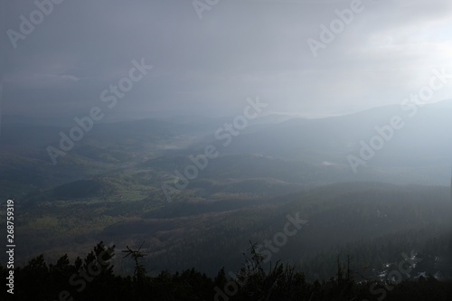 Babia Gora - mountain range in Beskid Zywiecki during spring with fog, clouds and sun