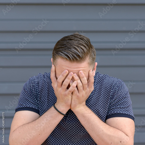 Depressed young man with his head in his hands