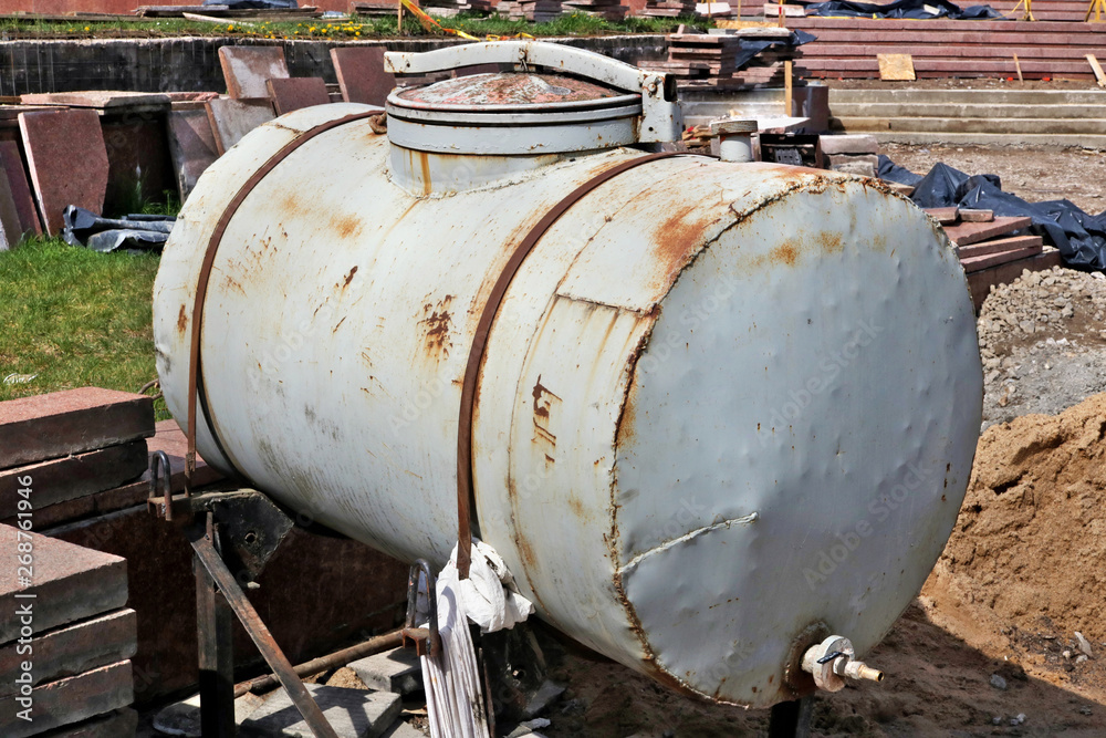 Large rusty steel barrel for technical water at construction site Large rusty steel barrel for technical water at construction site