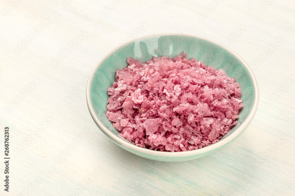 A bowl of pink Himalayan sea salt on a white wooden background with a place for text A bowl of pink Himalayan sea salt on a white wooden background with a place for text
