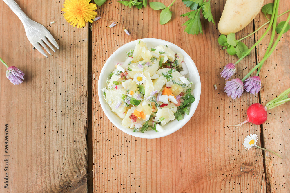 Schale Kartoffelsalat mit frischen Kräutern und essbaren Blüten