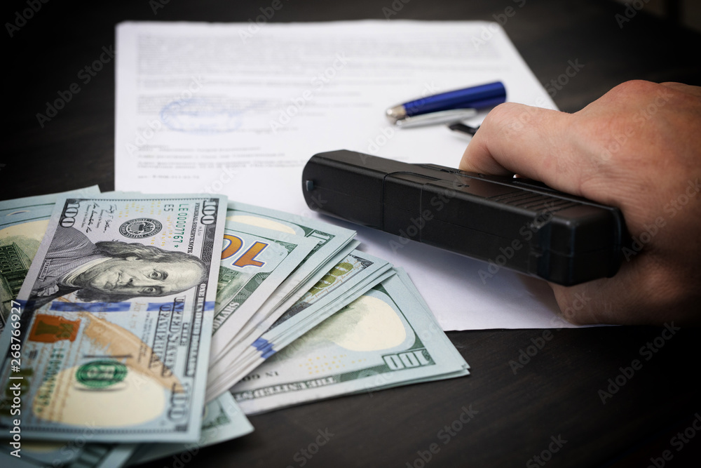 Businessmen use money to bribe, venality, crime, corruption concept. And guns or weapon in intimidation in exchange for signing contracts. Money - United States Dollars (or USD)