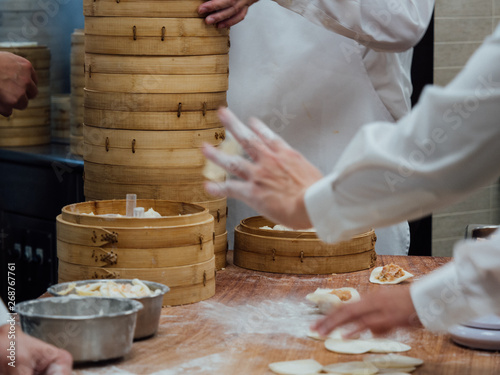 Workers in a kitchen making xiaolongbao or steamed dumplings at Din Tai Fung restaurant.