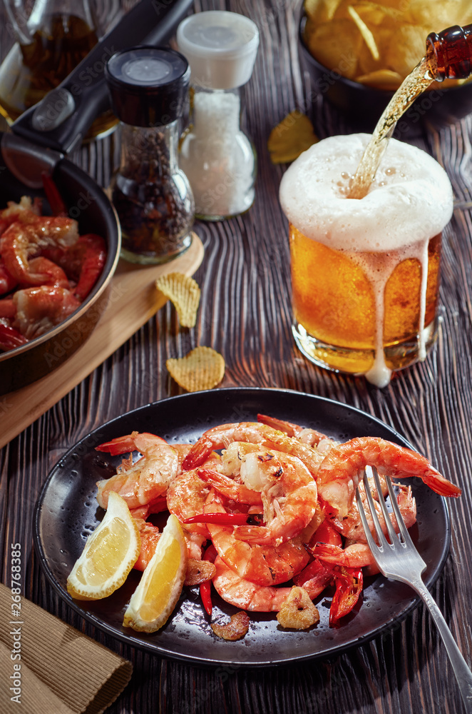 seafood at the bar, composition of black plate with shrimp lemon beer chips seafood at the bar, composition of black plate with shrimp lemon beer chips