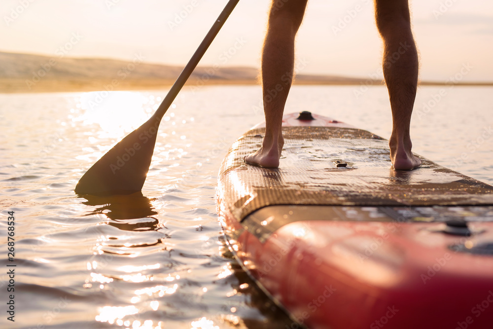 Person on paddle board at sunset - obrazy, fototapety, plakaty 