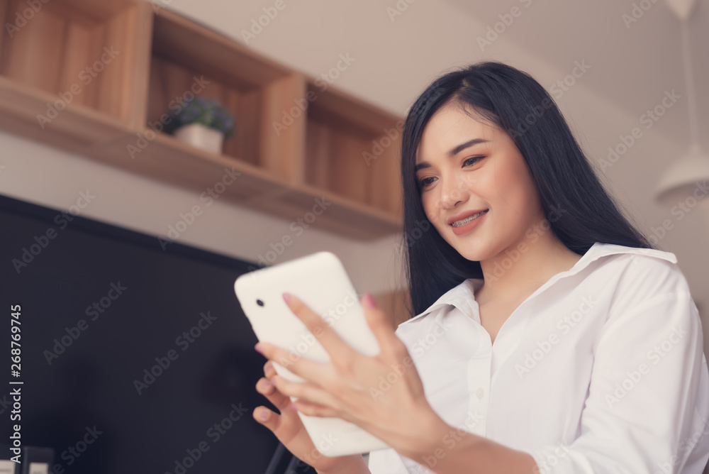 Young beautiful Asian Businesswoman to using tablet in office for customer contact and checking email . Business concept. Young beautiful Asian Businesswoman to using tablet in office for customer contact and checking email . Business concept.