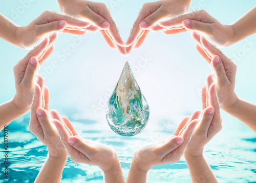 World water day and environmental protection concept with earth water drop in community volunteer's hands. Element of this image furnished by NASA