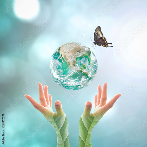 Fotografie Earth day and go green concept with big green planet on people's hand with tree leaves  : Elements of this image furnished by NASA