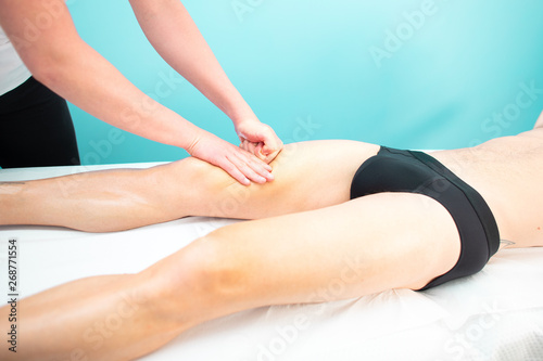 A masseur and physiotherapist quadriceps massage to an athlete