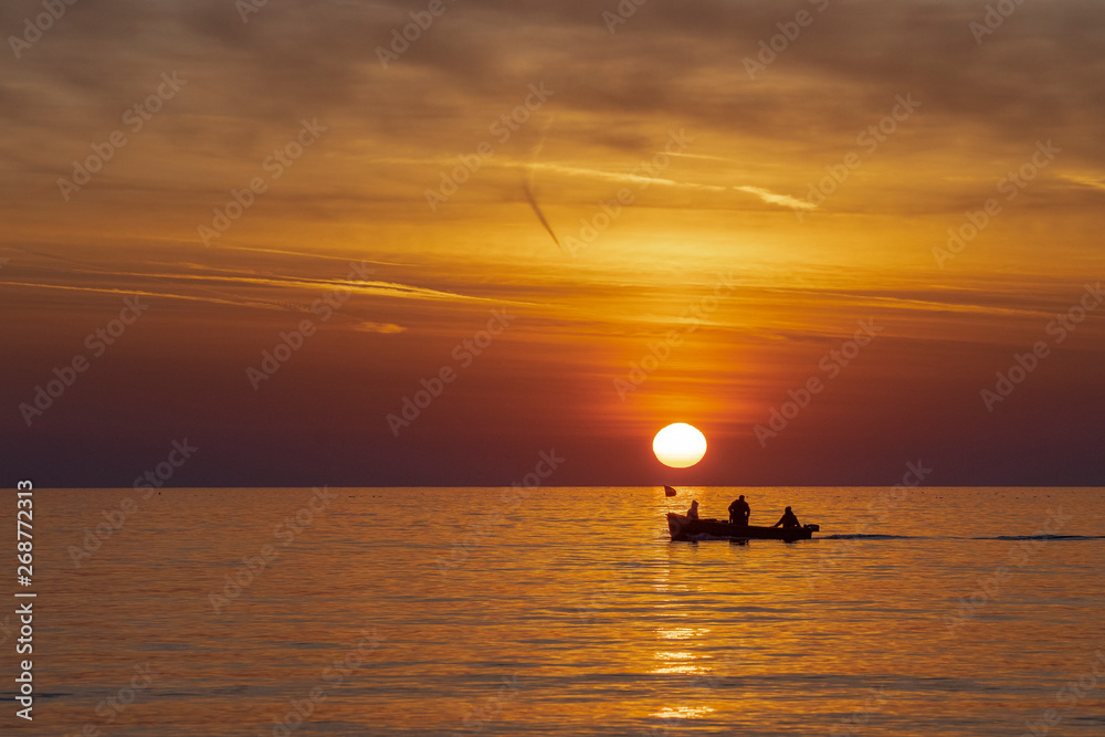 Fishermen in the sea at sunrise 