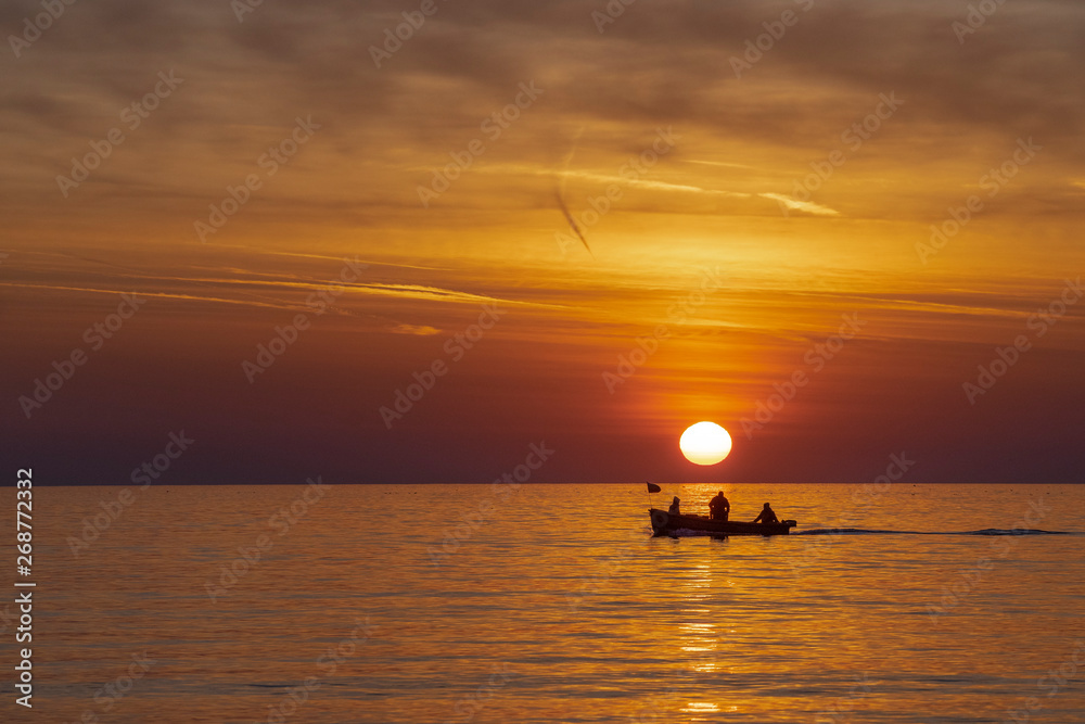 Fishermen in the sea at sunrise 