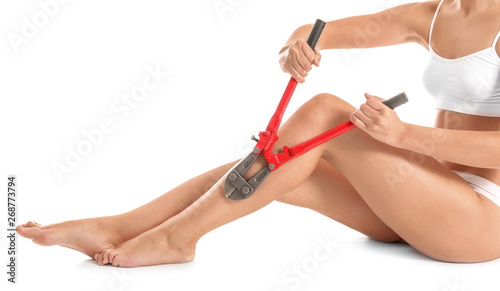 Tableau sur toile Beautiful young woman with nipping pliers on white background