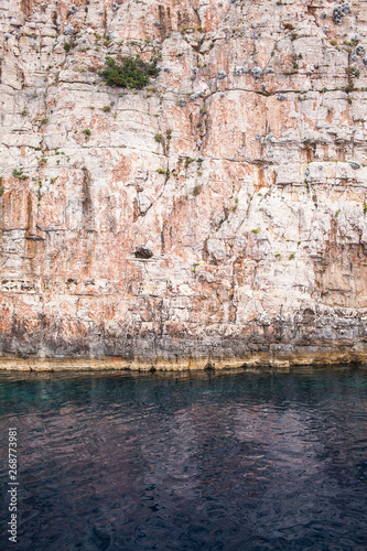 A large stone wall of beige stone in the sea