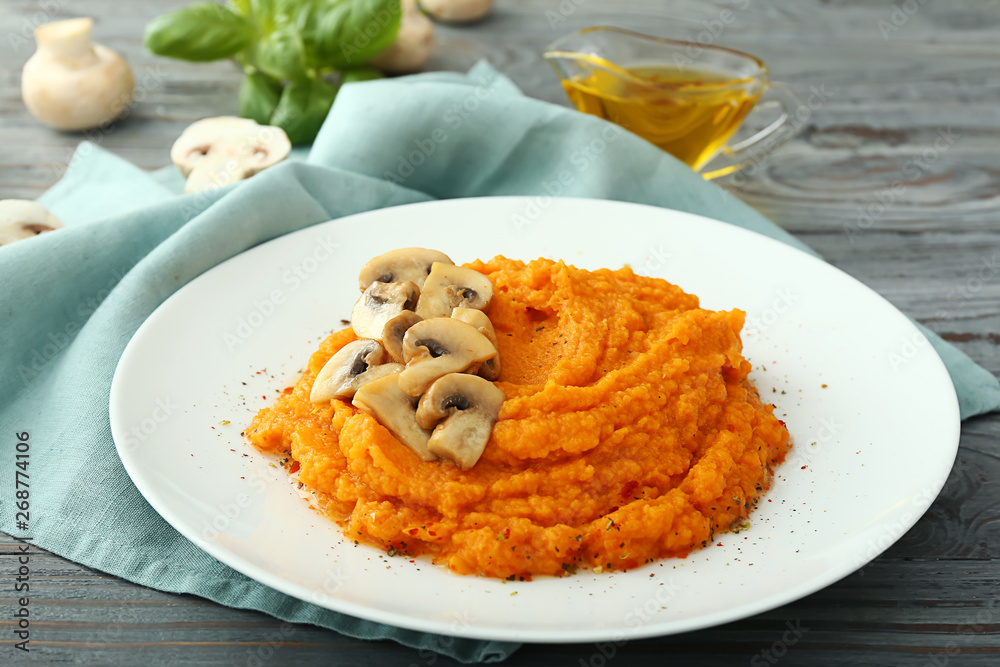 Plate with mashed sweet potato and mushrooms on wooden background Plate with mashed sweet potato and mushrooms on wooden background
