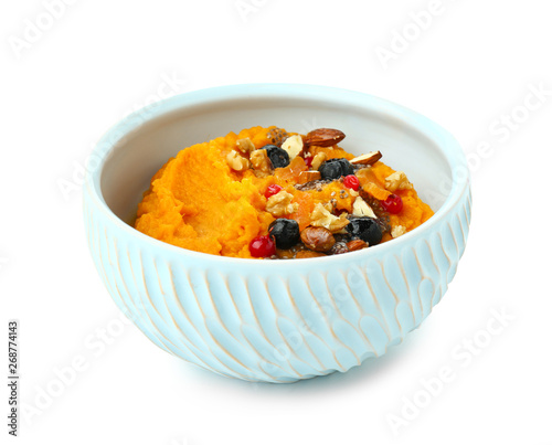 Bowl with mashed sweet potato, nuts and berries on white background