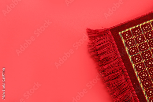 Muslim prayer rug on color background photo