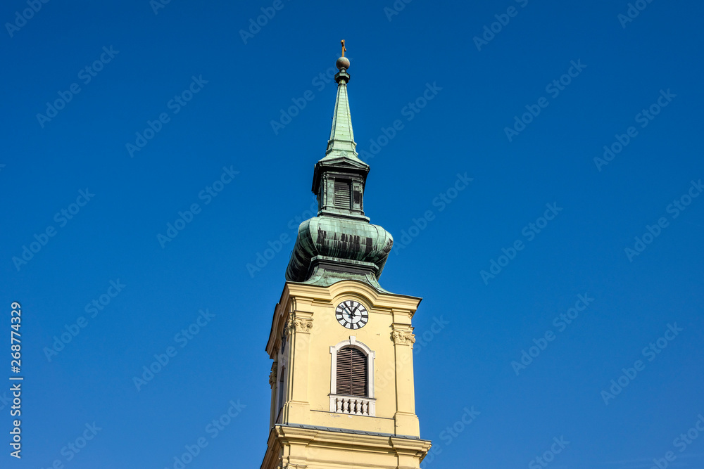 Hungary, Budapest, Buda: Steeple of famous St. Catherine of Alexandria Church in the city center of the Hunagian capital isolated on blue sky background - concept architecture history travel religion